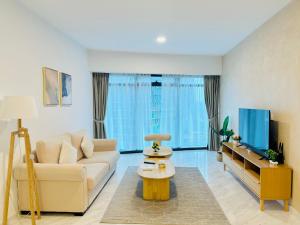 a living room with a couch and a tv at Eaton Service Apartment at KLCC in Kuala Lumpur