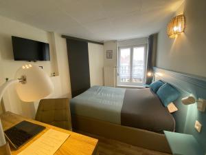 1 dormitorio con 1 cama y escritorio con ordenador portátil en Le Moment Douillet, en Bourbourg