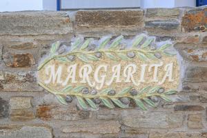 キオニアにあるMargarita's Kionia Beach Houseの煉瓦壁の看板