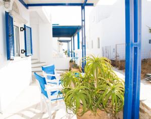 キオニアにあるMargarita's Kionia Beach Houseのポーチに置かれた青い椅子と植物