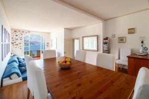 une salle à manger avec une table en bois et des chaises blanches dans l'établissement MINERVA HOUSE, à Rapallo