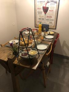 a wooden table with plates of food on it at Ferme Fleurie in Bergesserin