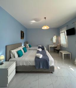 1 dormitorio con 1 cama grande y paredes azules en Myrto Hotel, en Koufonisia