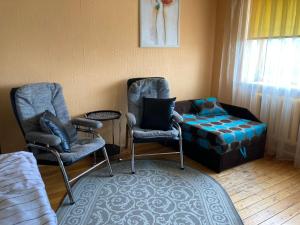 Studio tipa dzīvoklis في توكوموس: غرفة معيشة مع كرسيين وأريكة