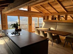 a kitchen with a counter and a table with chairs at Sporerhof Dolomitenlogen in Obergaimberg