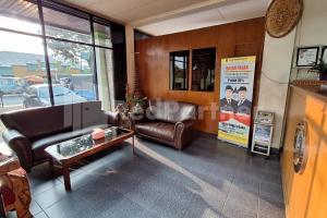 a living room with a couch and a table at Hotel Graha Muslim RedPartner in Bukittinggi