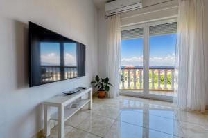 a living room with a tv and a large window at Apartman KALI in Kali