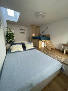 een slaapkamer met een groot blauw bed in een kamer bij Domek v srdci Fara in Faro