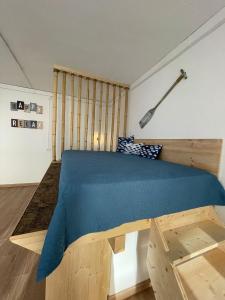 een slaapkamer met een houten bed en een blauwe deken bij Domek v srdci Fara in Faro