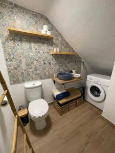 een badkamer met een toilet en een wasmachine bij Domek v srdci Fara in Faro