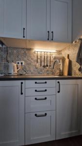 a kitchen with white cabinets and a counter top at Domek v srdci Fara in Faro +19 photos