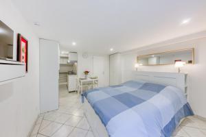a bedroom with a blue and white bed and a kitchen at Magnifique studio 20 m2 - Paris - Disneyland in Noisy-le-Grand