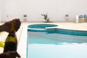 a dog is standing next to a swimming pool at Lamer villa in Al Ashkharah
