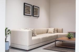 ein Wohnzimmer mit einem weißen Sofa und einem Tisch in der Unterkunft Lamer villa in Al Sharqiyah
