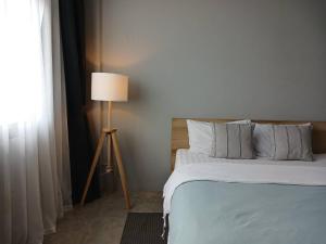 a bedroom with a bed and a floor lamp at Into the town krabi in Krabi