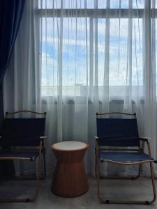 two chairs and a table in front of a large window at Into the town krabi in Krabi town