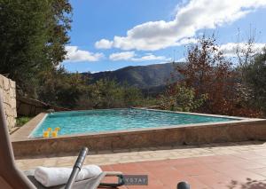 a swimming pool with a chair next to it at MyStay - Casa do Carmo in Alvite