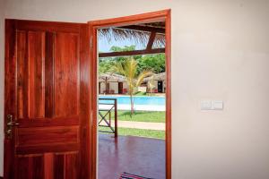 une porte ouverte avec vue sur la piscine dans l'établissement Blue Sky Resort, à Nosy Be