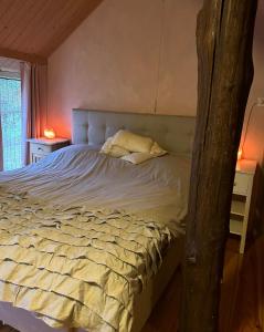 Un dormitorio con una cama grande con un árbol en Landgoed de Bongel, en De Wijk