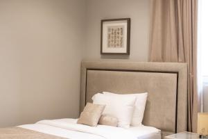 ein Bett mit weißen Kissen im Schlafzimmer in der Unterkunft Lamer villa in Al Sharqiyah
