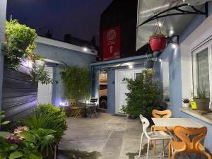 un patio nocturno con mesa y sillas en Le studio à découvrir., en Marquette-lès-Lille