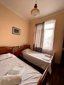 two beds in a room with a window at Apartment on SARYAN street 2/12 in Yerevan
