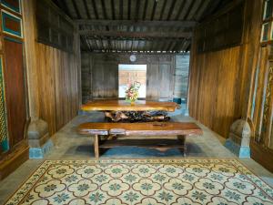 a dining room with a table and a rug at Puri Swantari Javanese Home Stay in Sleman