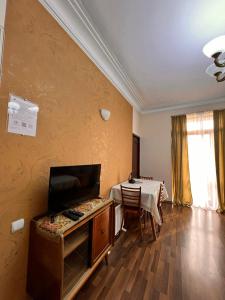a living room with a table and a television at Apartment on SARYAN street 2/12 in Yerevan
