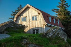 a house on top of a hill with a rock at Krokane Camping Florø in Florø