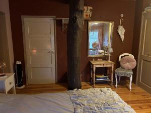 a bedroom with a bed and a mirror and a table at Landgoed de Bongel in De Wijk