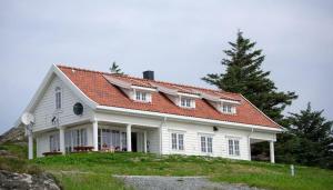 una casa blanca con techo naranja en una colina en Krokane Camping Florø, en Florø