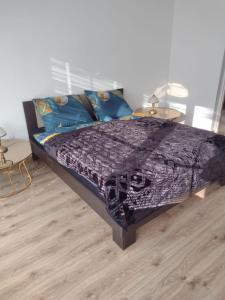 uma cama com um edredão roxo e duas mesas em La Casa De Roland em Wieliczka