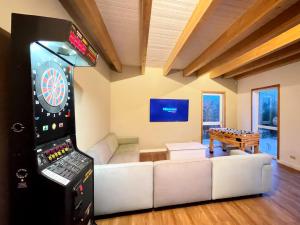 a living room with a dart board and a game console at Haus zwischen den Wehlen bei Büsum, 16 Personen in Westerdeichstrich