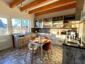 a kitchen with a table and chairs in it at Haus zwischen den Wehlen bei Büsum, 16 Personen in Westerdeichstrich