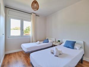 two beds in a room with a window at 0326 Apartment in Calella de Palafrugell in Calella de Palafrugell +9 photos