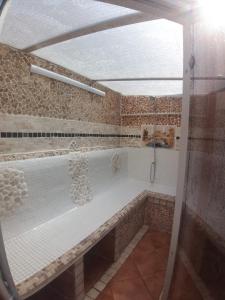 baño con ducha y banco. en La casa de huespedes, en Puebla de Vallbona