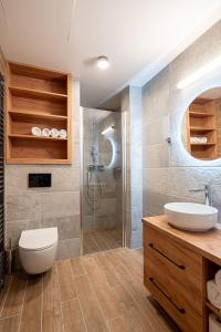 a bathroom with a sink and a toilet and a shower at Resort Aurum Residence A in Cerny Dul