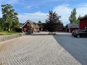 a gravel driveway in front of a red barn at Sanddala Bed & Breakfast in Everöd