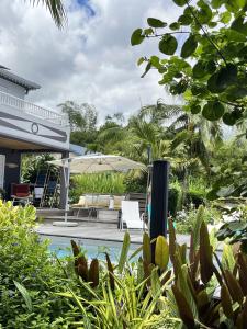 a backyard with a pool and an umbrella at Villa Galabé et Tafia in Sainte-Marie