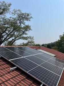 um grupo de painéis solares no topo de um telhado em Plum Cottage em Nelspruit