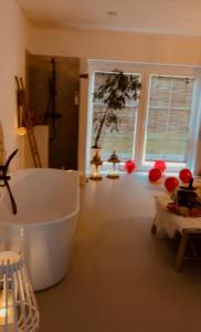 un bagno con vasca in una camera con finestre di Coco Suite a Amay