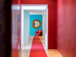 a red hallway with a red chair and a red carpet at Small Luxury Hotel Altstadt Vienna in Vienna
