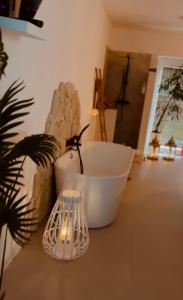een badkamer met een wit bad en een plant en een licht bij Coco Suite in Amay