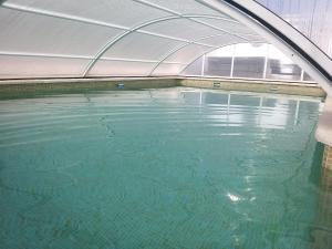 una piscina vacía con un arco sobre el agua en La casa de huespedes, en Puebla de Vallbona