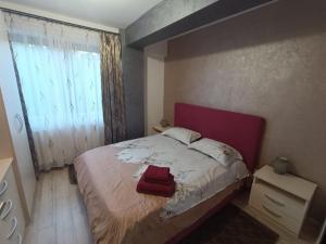 a bedroom with a bed with a red towel on it at Daylight Apartments Sibiu in Sibiu