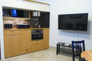 a kitchen with wooden cabinets and a tv on the wall at Chic Studio in Historic Kruununhaka, Helsinki in Helsinki