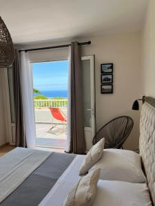 a bedroom with a bed and a view of the ocean at Villa Galabé et Tafia in Sainte-Marie