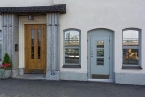 a building with three windows and a wooden door at Chic Studio in Historic Kruununhaka, Helsinki in Helsinki