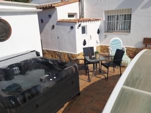 patio con bañera de hidromasaje y mesa en La casa de huespedes en Puebla de Vallbona