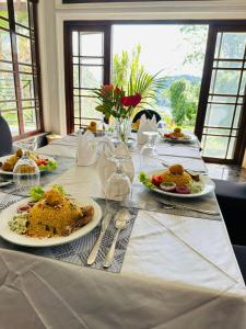 a white table with plates of food on it at Indra Manel Family Holiday Resort Kandy in Kandy